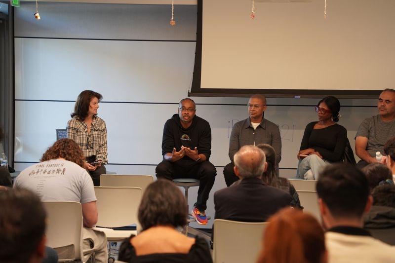 Kenan speaking on a panel discussion in front of an audience