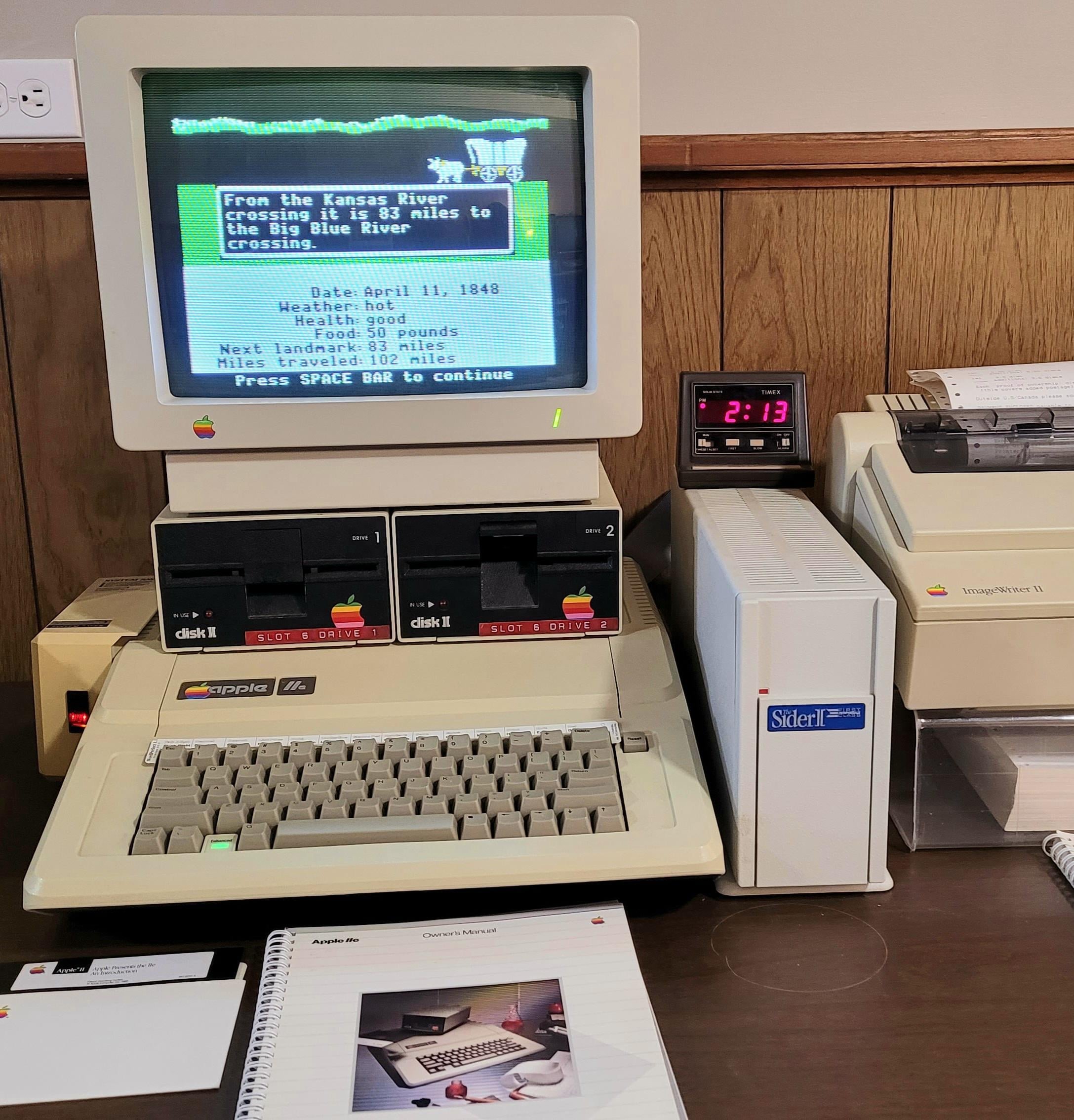An Apple IIe running Oregon Trail, with Disk II drives and an ImageWriter II printer